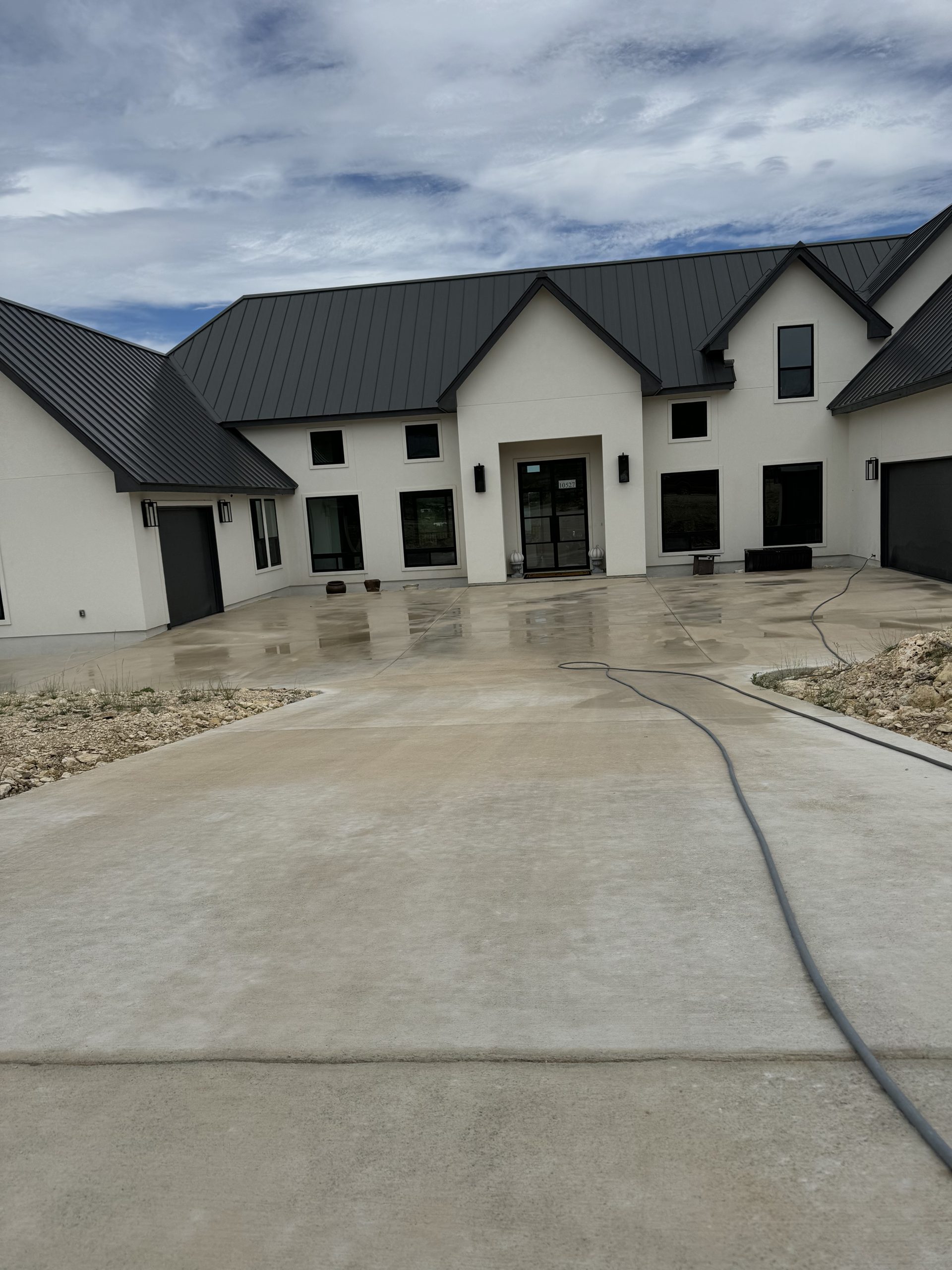 Modern home with soft-washed white siding and clean driveway
