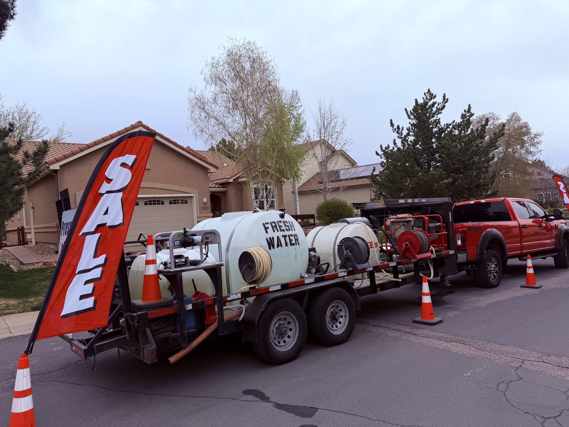 Pressure washing truck and fresh-water trailer on a Colorado jobsite