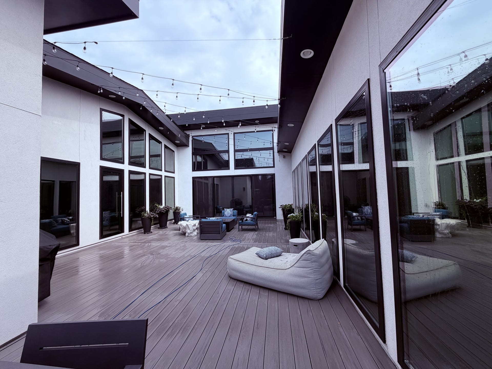 Modern courtyard with floor-to-ceiling glass and composite deck, freshly cleaned