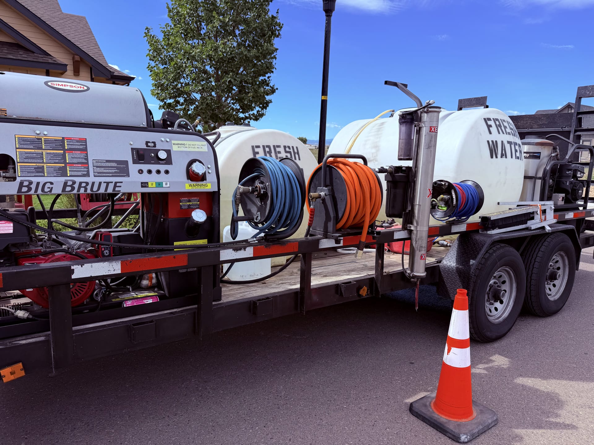 Hot-water pressure washing rig with fresh-water tanks on a trailer